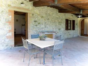 un tavolo e sedie di fronte a un muro di pietra di Apartment Tortora by Interhome a Santa Luce