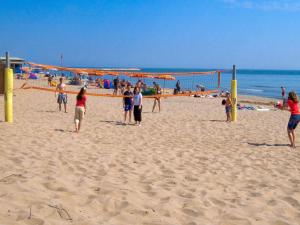 a group of people playing volley ball on the beach at Holiday Home Rosapineta Camping Village-2 by Interhome in Rosapineta