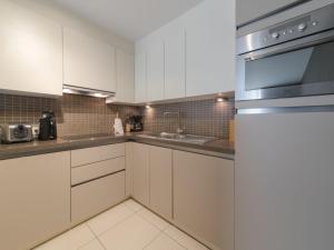 a kitchen with white cabinets and stainless steel appliances at Apartment Residentie Irena app-302 by Interhome in Bredene