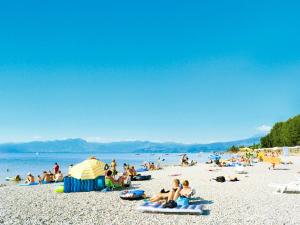 grupa ludzi siedząca na plaży w obiekcie Holiday Home Camping Butterfly-2 by Interhome w mieście Peschiera del Garda