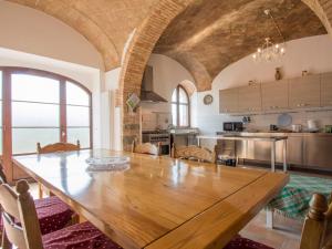duża kuchnia z drewnianym stołem w pokoju w obiekcie Holiday Home Podere Sant'Elisa-2 by Interhome w mieście Podere SantʼElisa
