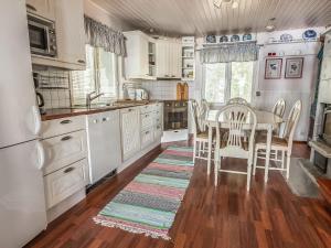 HitisにあるHoliday Home Helga by Interhomeの白いキャビネット、テーブルと椅子付きのキッチンが備わります。
