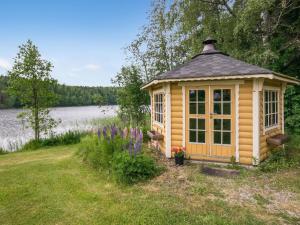 une cabane en bois dans l'herbe à côté d'un lac dans l'établissement Holiday Home Ahvenranta by Interhome, à Kosula
