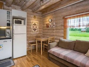 - un salon avec un canapé, un réfrigérateur et une table dans l'établissement Holiday Home Ahvenranta by Interhome, à Kosula