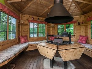 ein Wohnzimmer mit einem Herd in einer Blockhütte in der Unterkunft Holiday Home Ahvenranta by Interhome in Kosula