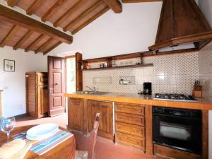 Podere CamininoにあるHoliday Home Il Pozzo by Interhomeのキッチン(木製キャビネット、コンロ付)