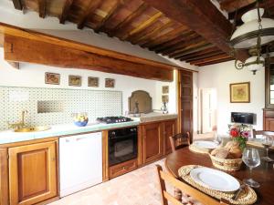a kitchen with wooden cabinets and a wooden table at Apartment Loggetta by Interhome in Podere Caminino +22 photos