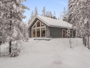 a house covered in snow in the woods at Holiday Home Luoston karpalo by Interhome in Luosto