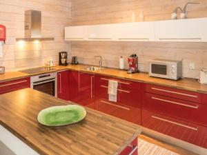 ルオストにあるHoliday Home Luoston karpalo by Interhomeのキッチン(赤いキャビネット、木製カウンタートップ付)
