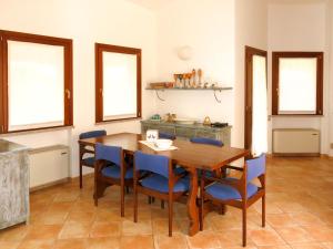 een eetkamer met een houten tafel en blauwe stoelen bij Holiday Home Rei Sole - REI300 by Interhome in Costa Rei