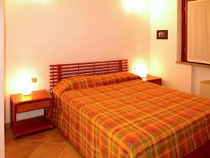 een slaapkamer met een bed en twee nachtkastjes met lampen bij Holiday Home Rei Sole - REI300 by Interhome in Costa Rei