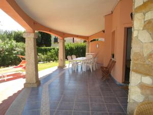een terras met een tafel en stoelen bij Holiday Home Rei Sole - REI300 by Interhome in Costa Rei