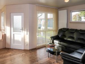 uma sala de estar com um sofá de couro preto e uma porta em Holiday Home Erzeberg-4 by Interhome em Balhorn