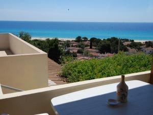un vaso seduto su un tavolo su un balcone affacciato sull'oceano di Holiday Home Belvedere Trilo by Interhome a Costa Rei