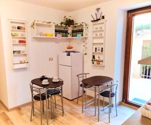 une petite cuisine avec deux tables et un réfrigérateur dans l'établissement IL VILLAGGIO DELLE FATE, à Macerata