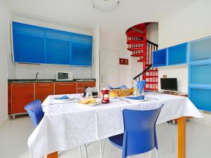 リニャーノ・サッビアドーロにあるApartment Parco Hemingway-2 by Interhomeのキッチン(白いテーブル、青い椅子付)