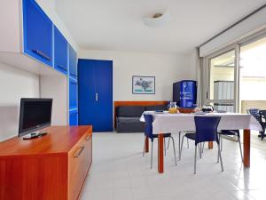 リニャーノ・サッビアドーロにあるApartment Parco Hemingway-2 by Interhomeのキッチン(青いキャビネット、テーブル、椅子付)