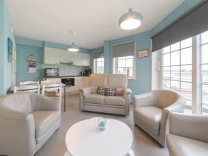 a living room with two chairs and a table at Apartment Vosseslag I sunny by Interhome in De Haan