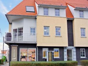 una casa grande con techo naranja en Apartment Vosseslag I by Interhome en De Haan