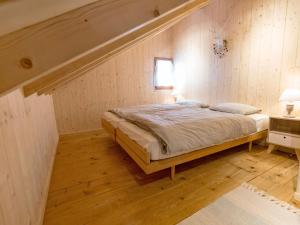 ein Schlafzimmer mit einem Bett in einer Holzwand in der Unterkunft Chalet Chalet de la Vue des Alpes by Interhome in La Vue des Alpes