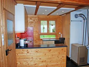 - une cuisine avec des murs en bois et un comptoir en bois dans l'établissement Chalet Chalet de la Vue des Alpes by Interhome, à La Vue des Alpes