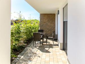 een patio met stoelen en een tafel aan de zijkant van een huis bij Apartment Seglerhütte by Interhome in Großpösna