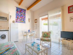 ein Wohnzimmer mit einem Tisch und einem TV in der Unterkunft Holiday Home Les Cristallines-3 by Interhome in Cap d'Agde