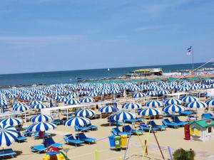 a bunch of blue and white umbrellas on a beach at Apartment Bellavista 6 by Interhome in Cattolica