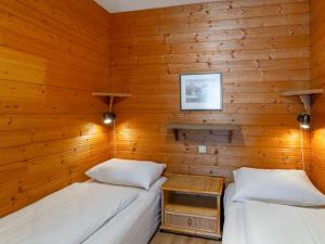 two beds in a room with wooden walls at Apartment Plathner by Interhome in Bad Hofgastein
