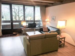 a living room with a couch and a large window at Apartment Plathner by Interhome in Bad Hofgastein +36 photos
