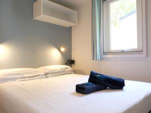 a white bed with a blue bag sitting on it at Holiday Home Internazionale Manacore by Interhome in Peschici +29 photos