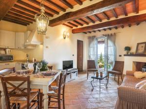 una cucina e un soggiorno con tavolo e sedie di Apartment Appartamento Ginepro - Borgo in Chianni by Interhome a Chianni