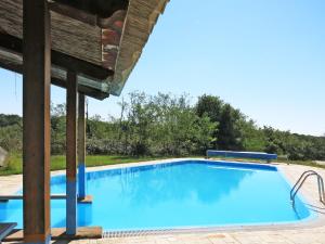 a large blue swimming pool with a wooden roof at Apartment Le Palaie - 'Padronale' - PEC209 by Interhome in Montecchio