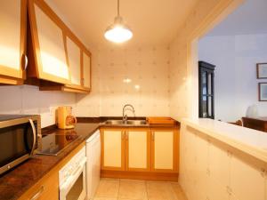 cocina con fregadero y microondas en Apartment Sa Guilla 3 dorm by Interhome, en Begur