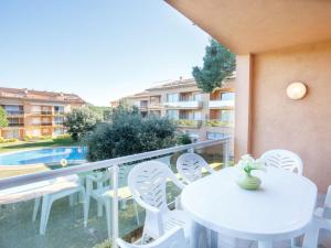 un balcón con mesas y sillas blancas y una piscina en Apartment Sa Guilla 3 dorm by Interhome, en Begur