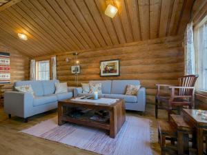 ein Wohnzimmer mit einem Sofa und einem Couchtisch in der Unterkunft Holiday Home Tatunmökki by Interhome in Huuhanaho