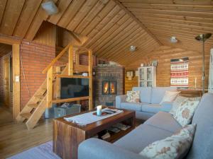 een woonkamer met een bank, een tv en een tafel bij Holiday Home Tatunmökki by Interhome in Huuhanaho