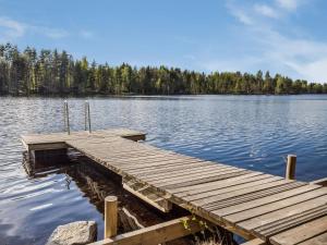 a wooden dock in the middle of a lake at Holiday Home Papanmökki by Interhome in Huuhanaho