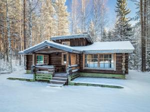 a log cabin in the woods in the snow at Holiday Home Papanmökki by Interhome in Huuhanaho