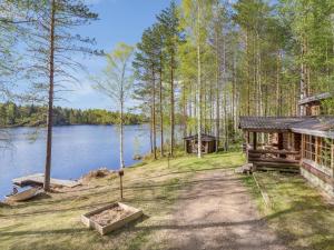 uma cabana na floresta ao lado de um lago em Holiday Home Papanmökki by Interhome em Huuhanaho