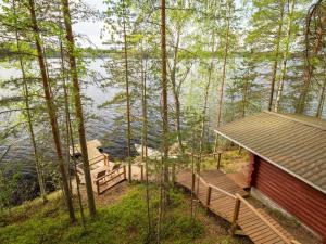 a cabin in the woods with a view of the water at Holiday Home Pohosniemi by Interhome in Huuhanaho