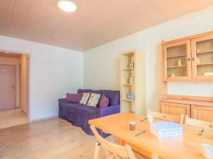 a living room with a blue couch and a table at Studio Le Sefcotel - Val Claret-21 by Interhome in Tignes