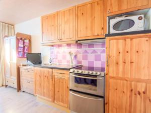 a kitchen with wooden cabinets and a microwave at Studio Le Sefcotel - Val Claret-21 by Interhome in Tignes