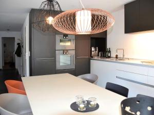 una cocina con una mesa con sillas y una lámpara. en Apartment Raber by Interhome en Churwalden