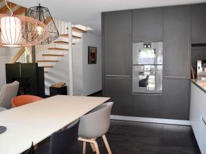 a kitchen with a table and chairs and a staircase at Apartment Raber by Interhome in Churwalden