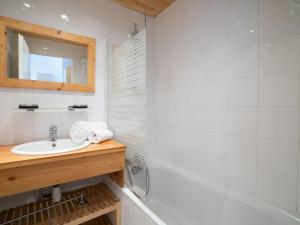 bagno con lavandino, vasca e specchio di Apartment Le Hameau du Borsat-8 by Interhome a Tignes
