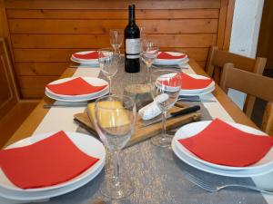 - une table avec des assiettes rouges et blanches et des verres à vin dans l'établissement Apartment Le Hameau du Borsat - Val Claret-9 by Interhome, à Tignes