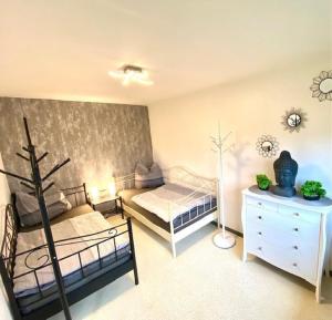 a bedroom with two beds and a dresser with a lamp at Ferienwohnung Vogel in Selbitz