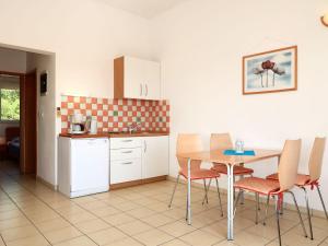 a kitchen with a table and chairs in a kitchen at Apartment Andrea - RAB100 by Interhome in Rab