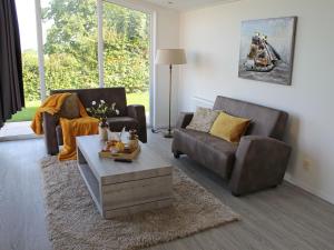 ein Wohnzimmer mit 2 Sofas und einem Couchtisch in der Unterkunft Holiday Home Green Resort Mooi Bemelen by Interhome in Bemelen